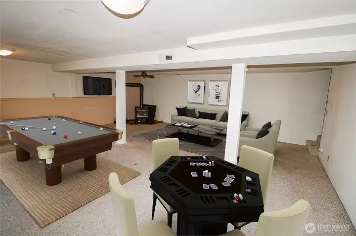 The daylight basement family room, virtually staged with a pool table and game table to show its potential as the ultimate rec room.