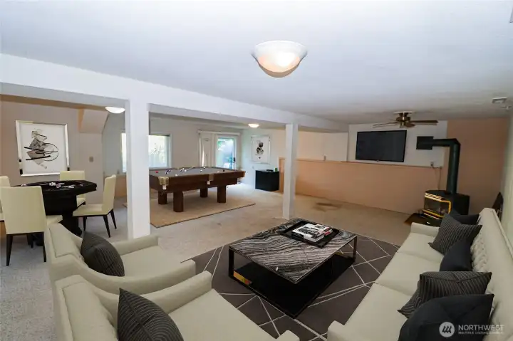 Another look at the lower level family room, virtually staged, showing the wood stove and plenty of space to spread out.
