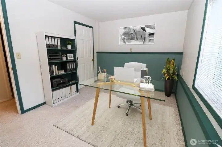 A downstairs den or home office setup, virtually staged. This flexible space could easily serve as a guest room, office, or studio.