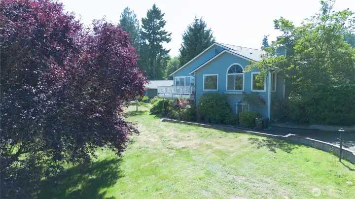 A side view of the home's classic PNW styling, with the wraparound deck wrapping toward the back of the house.