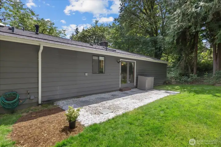 Relax in the backyard on the patio surrounded by mature landscaping and nature.