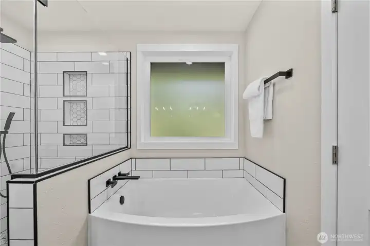 Large soaking tub is featured in Primary Ensuite Bathroom.