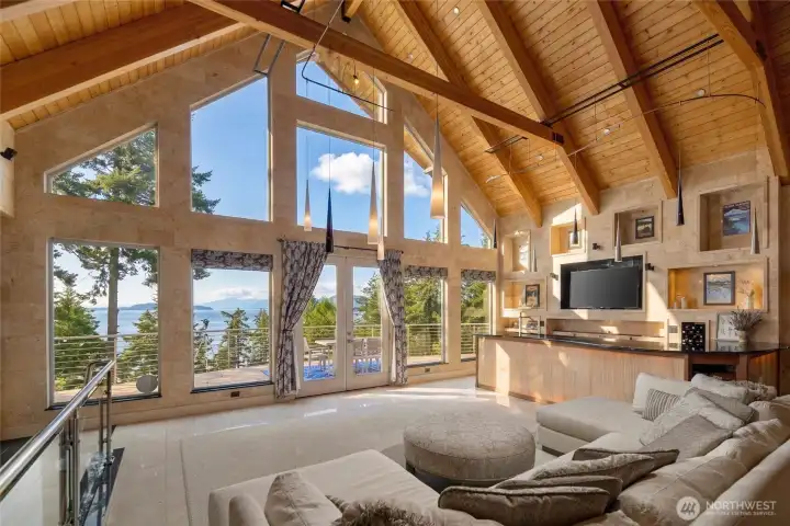 Soaring fir ceilings, exposed timber framing, expansive windows, and floor-to-ceiling stonework define the elevated great room.