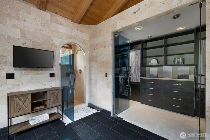 Primary suite amenities include a custom walk-in closet with built-in storage and an adjoining glass-enclosed shower.