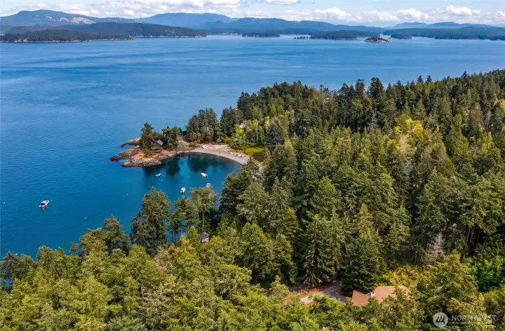Aerial view captures the nearby community beach, protected bay, surrounding islands, and expansive waters of the San Juan Channel.