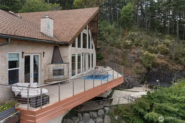 The wraparound deck and lower patio create multiple spaces for outdoor dining, relaxing, and entertaining amid the island landscape.