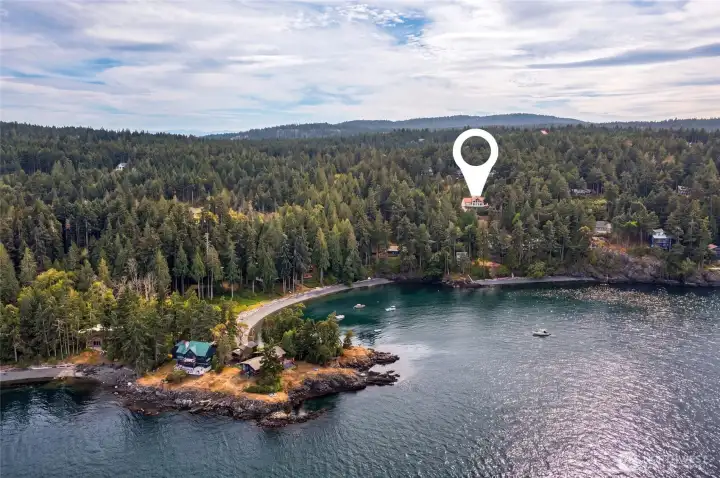 Aerial perspective highlights the home’s elevated location above a protected bay with convenient community beach access nearby.
