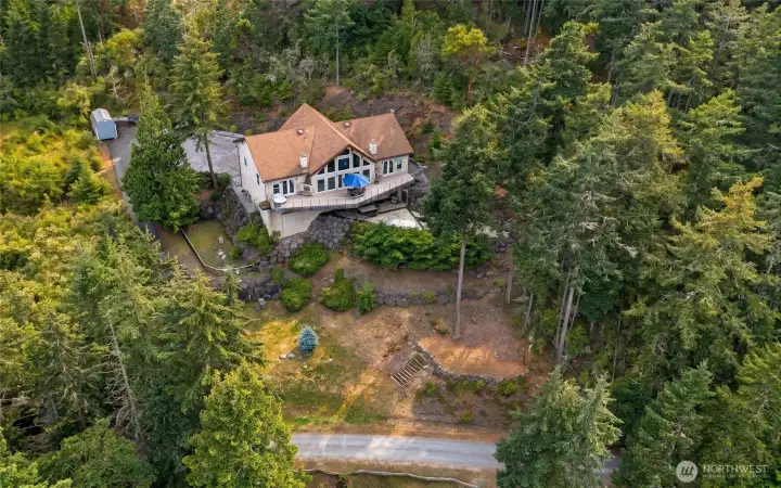 Outlined aerial view highlights the residence and its private 0.95-acre setting surrounded by established forest and island homes.