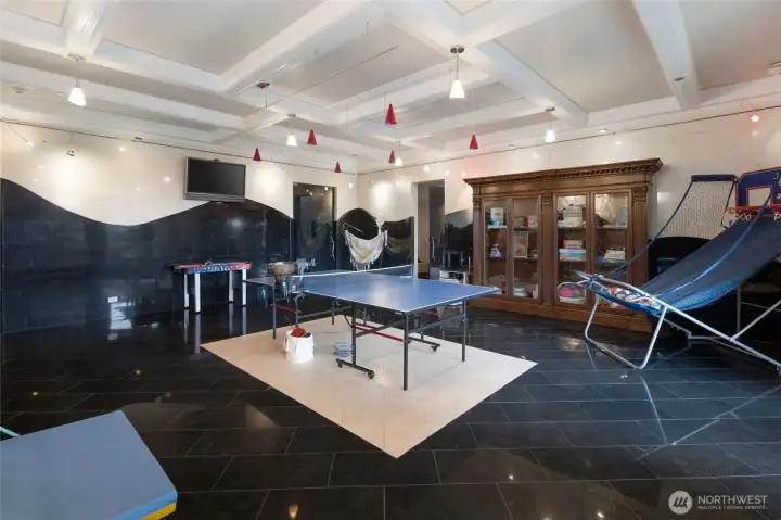 Expansive game room offers multiple activity areas, integrated lighting, built-in storage, and flexible use for entertaining.