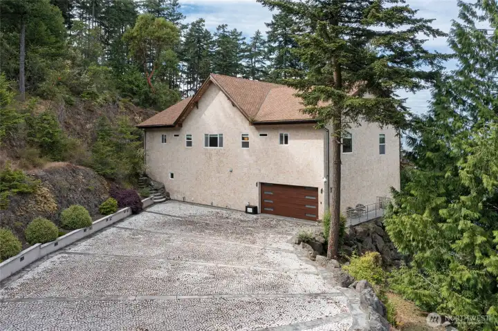 Spacious patterned driveway leads to the finished garage and provides convenient parking within the home’s wooded San Juan Island setting.