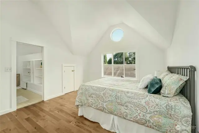The primary bedroom features dramatic vaulted ceilings and round window through which you can spy the moon if your timing is right.