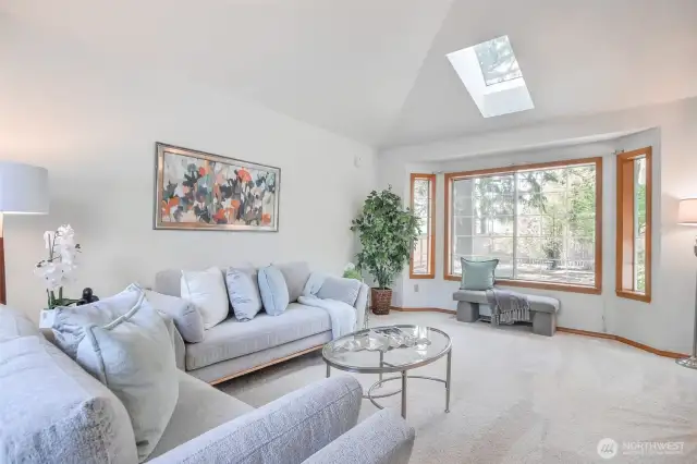 Formal living room with vaulted ceilings and skylight.