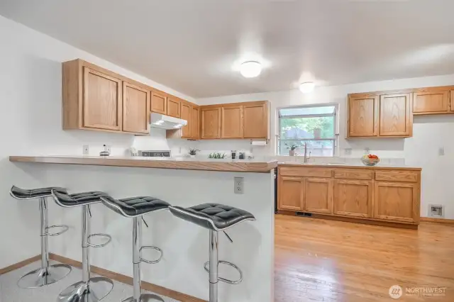 Kitchen with bar and lots of counter and shelving space.