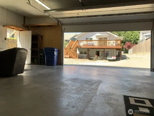This photo was taken from inside the garage looking out to the long driveway, patio and back of house.