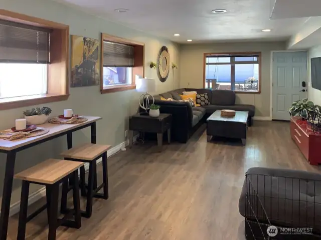 This is the great room on the lower level. The door you see here is the exterior entrance to this level. Vinyl plank flooring is easy maintenance. Just outside the door, to the right is the covered hot tub.