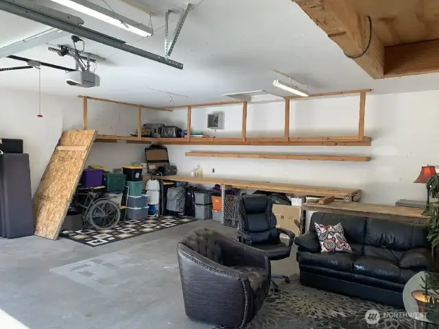 The extra long work bench allows for displaying things or layout your next project. Attic storage accessed by a ladder. (not provided)