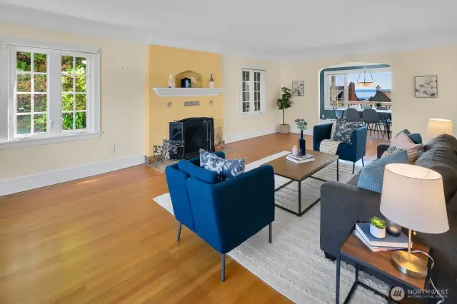 Spacious living room ~ Gorgeous hardwood floor & wood-burning fireplace ~ Dining room in the background