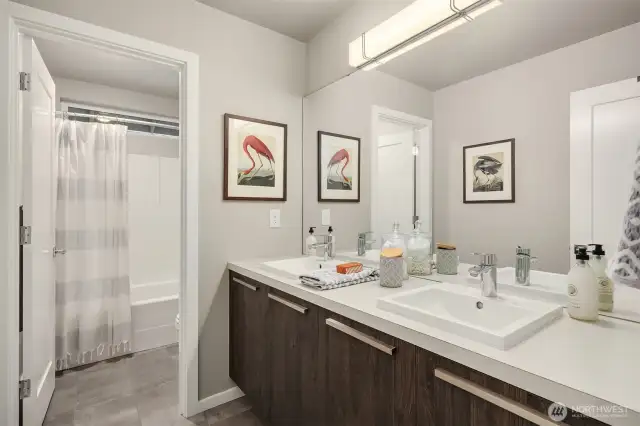 Full hall bath enjoys tile floors and double vanites.