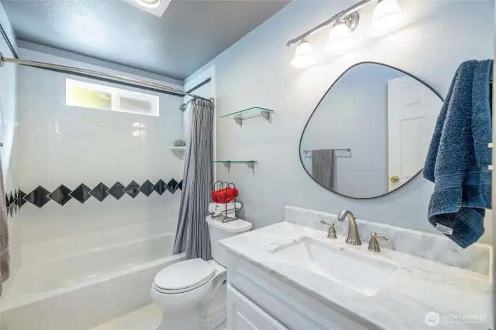 Wonderfully remodeled guest bathroom with tile floors.