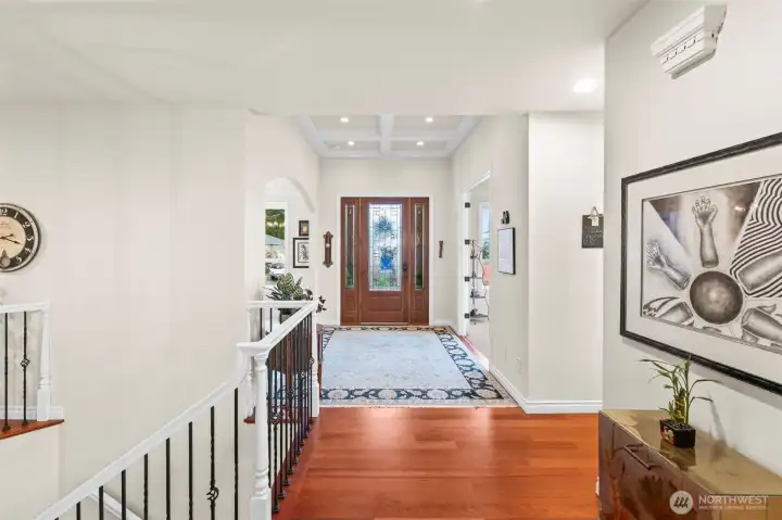 Elegant front hallway with coffered ceilings, hardwood floors, and a beautiful view toward the custom front entry.