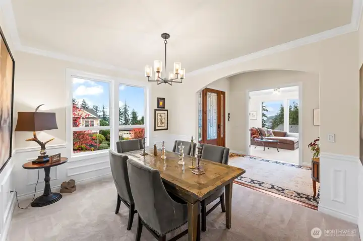Formal dining room with classic millwork, abundant natural light, views of the meticulously landscaped front gardens and filtered Sound views through the evergreens.
