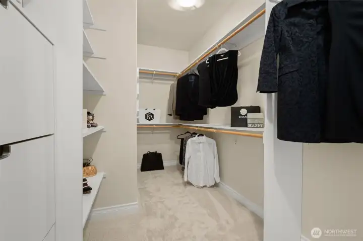 Generous walk-in closet with built-in shelving and ample storage, designed for everyday convenience.