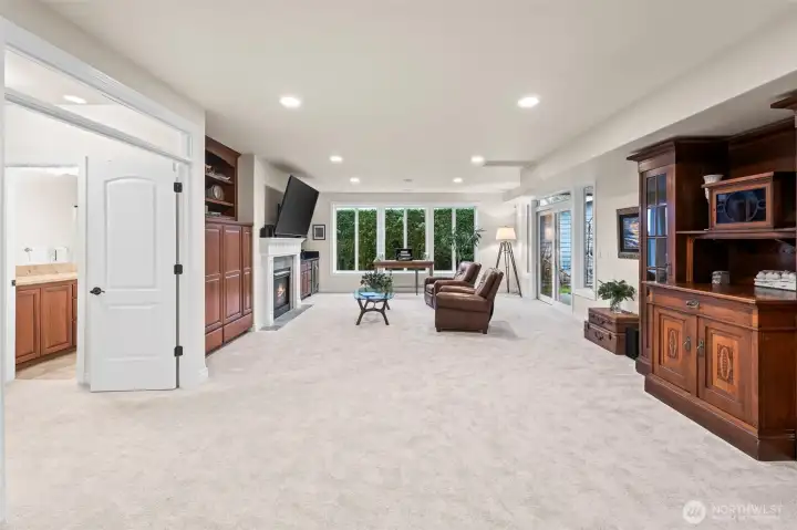 This home's versatility is a signature feature.  The lower level will be a delightful surprise.  Here is the living room with fireplace, wall-to-wall windows, and abundant space for multi-generational living or recreation.