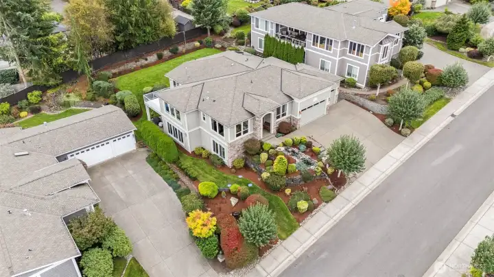 Aerial view capturing the home’s elegant footprint, manicured grounds, and quiet Grace Cove streetscape.