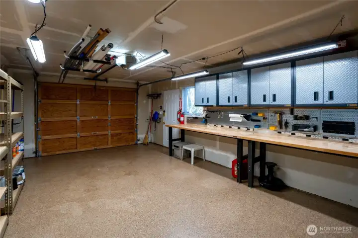 Detached garage with finished floors, gar door opener, included shelving & tables