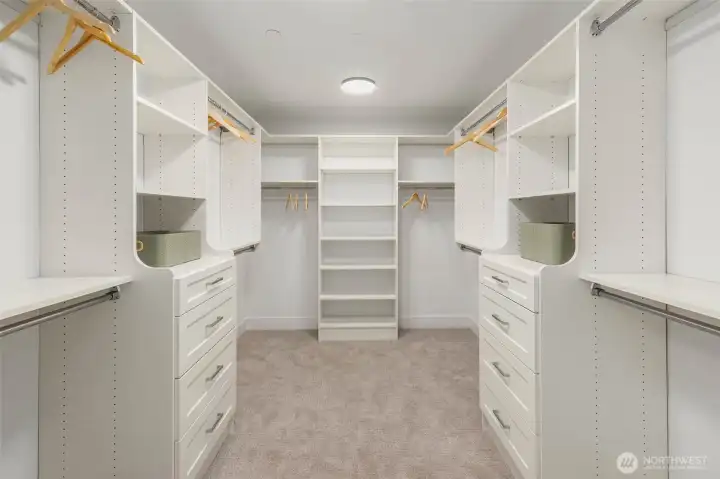 Spacious primary closet with custom designed and built solid shelving and drawers. Solid closet shelving throughout the home
