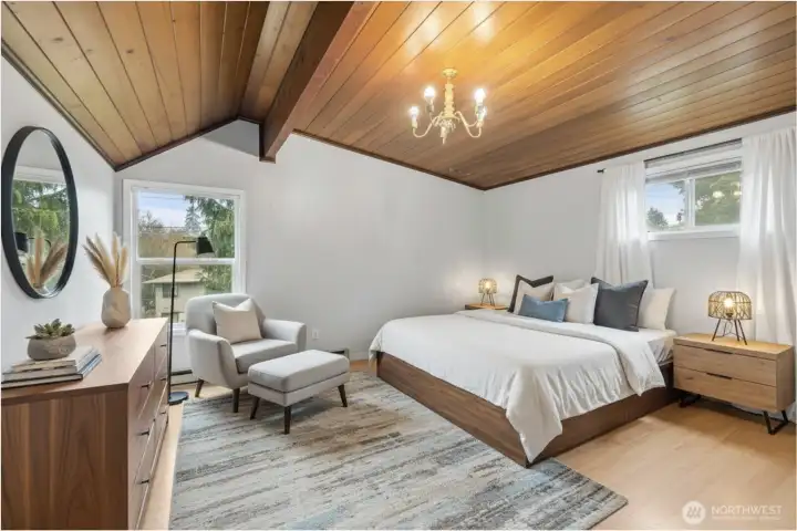 Virtually staged upper-level bedroom with natural light and beautiful wood ceiling