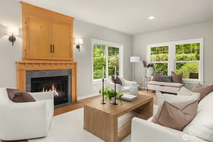 Light moves easily through the home, settling into spaces designed for comfort. Soft tones, warm wood, and windows that frame the greenery create a living room that feels both open and grounded.