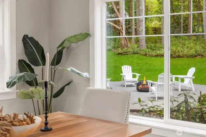 Just beyond, a quiet moment unfolds—sunlight pouring through expansive windows, drawing the eye outward to a private patio immersed in green.