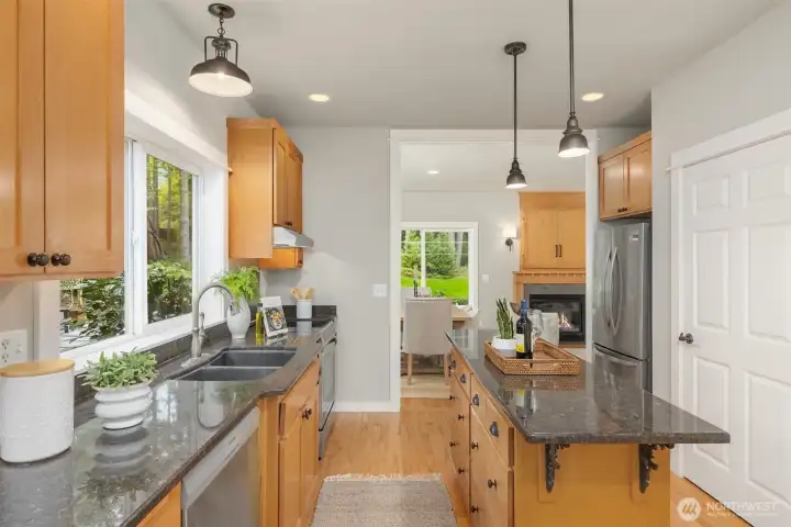 The kitchen is both refined and functional—crisp surfaces, warm wood cabinetry, and a generous island designed for gathering, prep, and everyday connection.