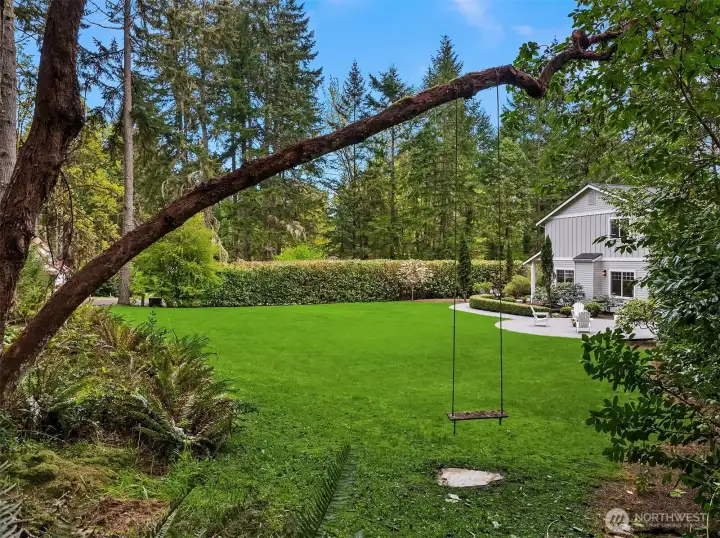 Expansive and beautifully private, the level lawn unfolds as a true extension of the home—offering space to gather, play, and entertain, all set against a backdrop of mature evergreens.