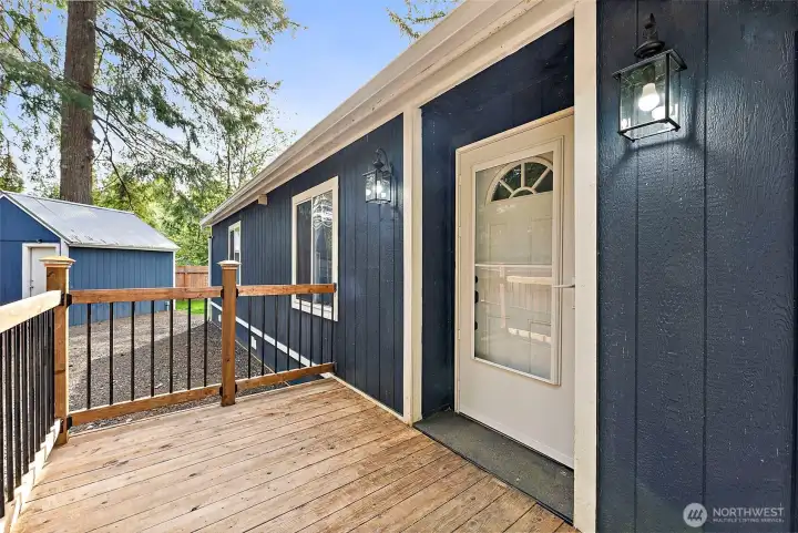 Welcoming front entry with covered porch, updated exterior lighting, and fresh modern paint