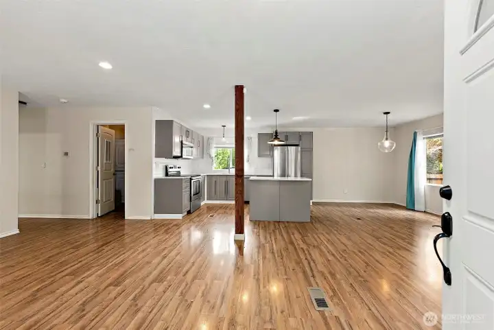 Spacious open-concept living area with new flooring and seamless flow into kitchen