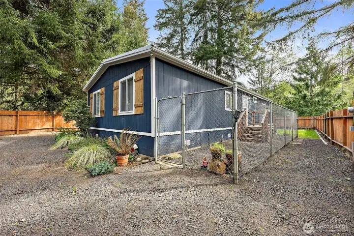 Side yard with gated enclosure and gravel parking area