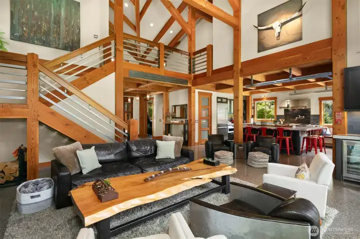 Expansive great room showcases the full timber frame superstructure with authentic mortise-and-tenon joinery, anchored by ground and polished concrete floors with in-floor hydronic radiant heat. Seamless architectural sightlines lead directly into the high-end chef's kitchen and up to the versatile loft area.