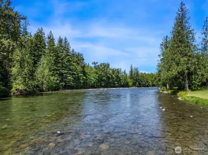 A majestic, wide-angle view of your private riverfront paradise. The crystalline waters, smooth stone riverbeds, and towering evergreens create an irreplaceable natural backdrop for this world-class estate.