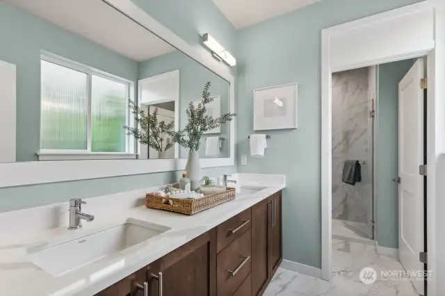 Primary bath has dual sinks and tiled flooring