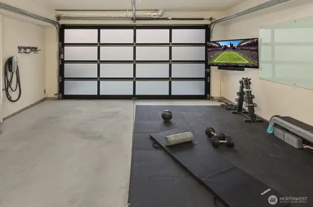 Clean 2-car garage with natural light and wired smart TV for multiple use.