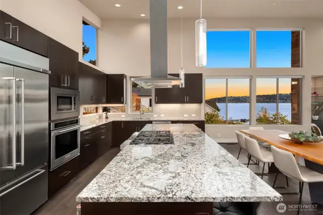 large kitchen island with stool seating. Vented gas range. Wine fridge under island counter.