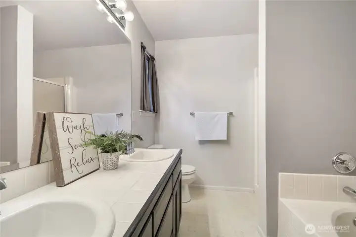 Primary bathroom with dual sinks, separate shower and soaking tub
