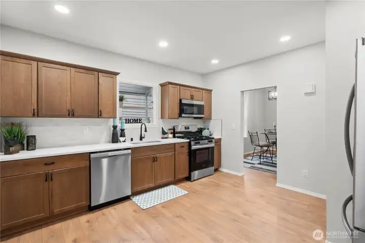 Gourmet Kitchen w/Brand New Cabinets w/Crown Molding and Pulls/Knobs. Quartz Counters, Full Tile Backsplash. Stainless Single Basin Sink w/New Pull Down Faucet. Garden Window over Sink is a fantastic place to grow basil & mint!