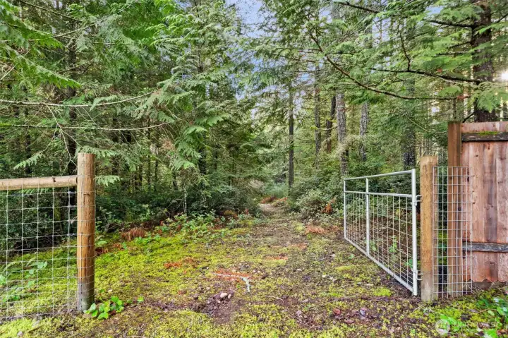 Gate leading to trails through the woods at back of property.