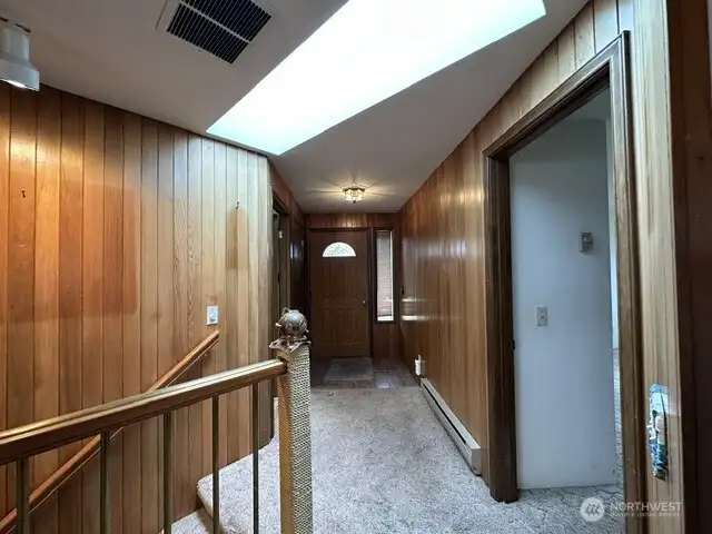 Looking to towards the front door. Stairs lead down to the basement. Hallway on the right leads to 2nd full bath and 2nd bedroom.