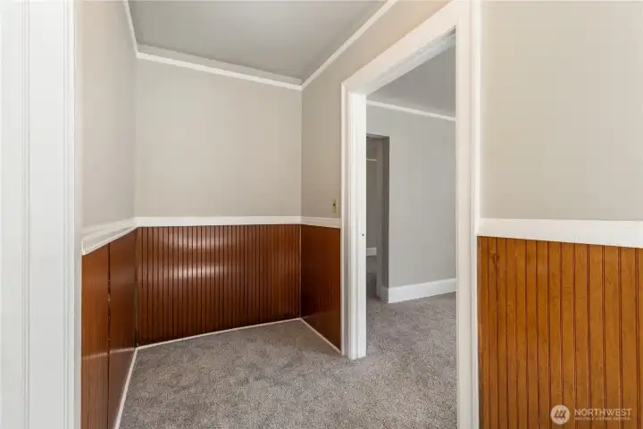 Walk way view from dining room leading to great room showing off beautiful wood wrapped wainscotting and white trim