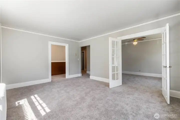 View of great room looking into bedroom with glass french doors and ceiling fan to keep you cool
