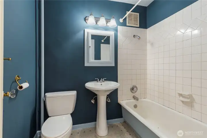 Here is view of large bathroom with new earth tone colors,new updated lighting pedistal sink tile wrapped soaking tub and vanity ready for all your needs.  There is tile flooring for easy maintence.  Come check out soon before it sells